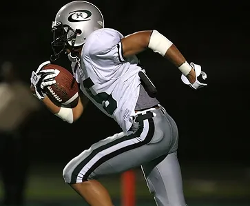 American football player running with the ball during a game