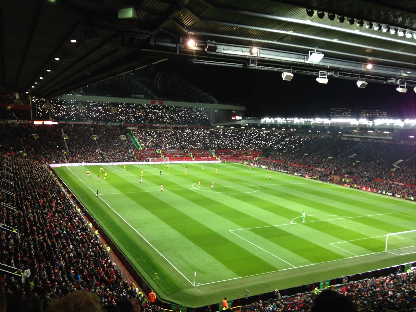 A floodlit stadium packed with supporters during an evening match