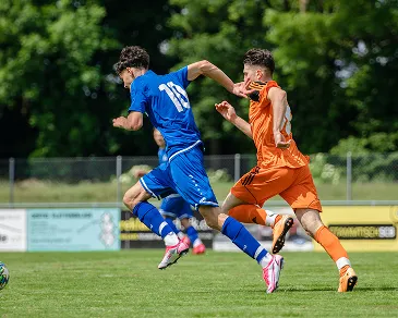 Two footballers competing for the ball during a match
