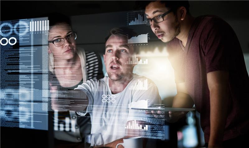Three people looking at data displayed on a screen